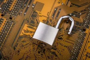 Open silver padlock lies on top of copper circuit board - dell