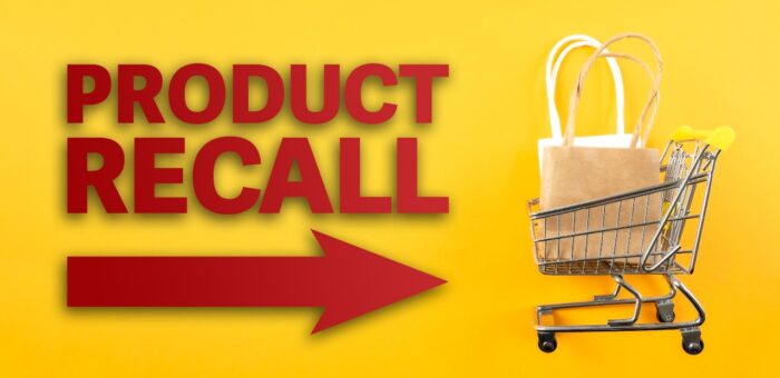 red text PRODUCT RECALL and arrow symbol against yellow background with shopping cart filled with shopping bags