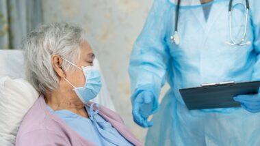 Asian doctor wearing face shield and PPE suit