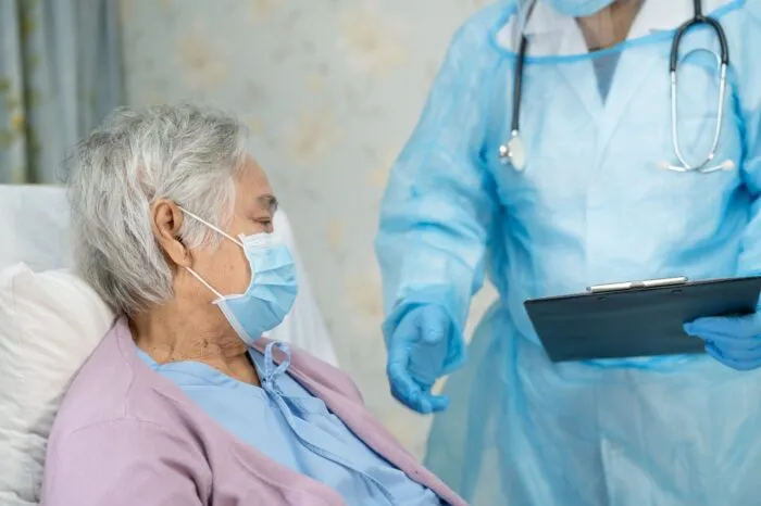 Asian doctor wearing face shield and PPE suit