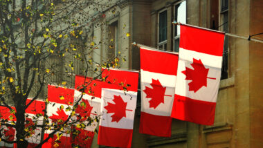 Close up of a row of Canadian flags outside Canada House in Trafalgar Square, London.