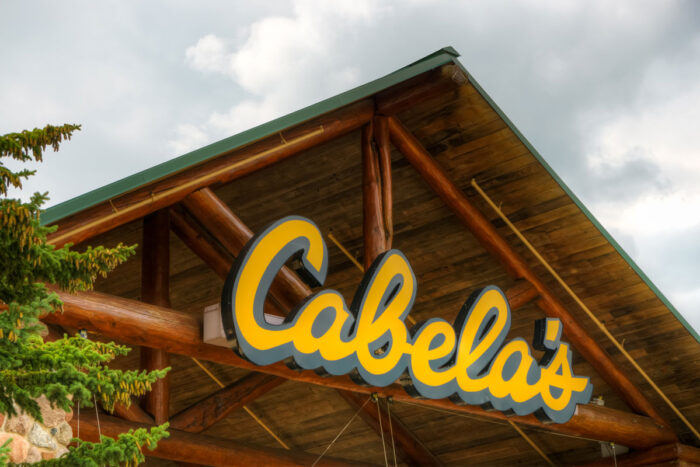 Close up of exterior Cabela's signage against a cloudy sky.
