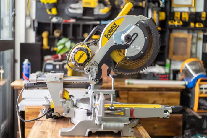 DEWALT sliding compound miter saw on wooden teble at carpenter workplace.