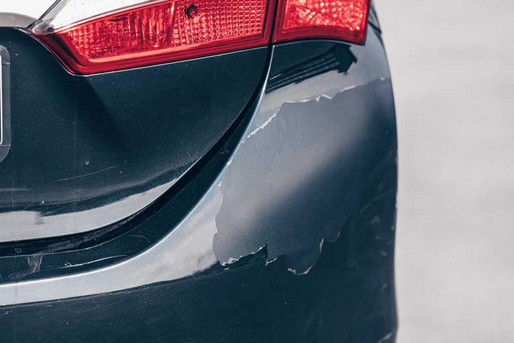 Close-up of paint on a bumper cracking and peeling, representing the Honda paint defect class action lawsuit settlement.