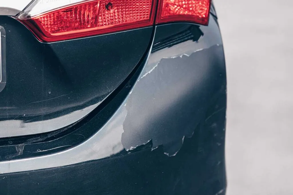 Close-up of paint on a bumper cracking and peeling, representing the Honda paint defect class action lawsuit settlement.