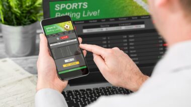 Close up of a man betting on sports on his smartphone.