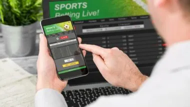 Close up of a man betting on sports on his smartphone.