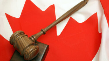 A wooden gavel on top of a Canada flag.