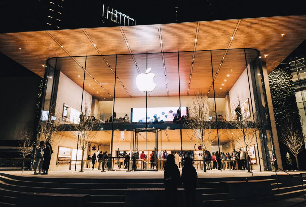 Exterior of an Apple Store at night, representing the AppleCare warranty settlement.