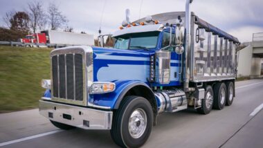 A blue heavy-duty work truck on the road, representing the Navistar MaxxForce engine class action settlement.