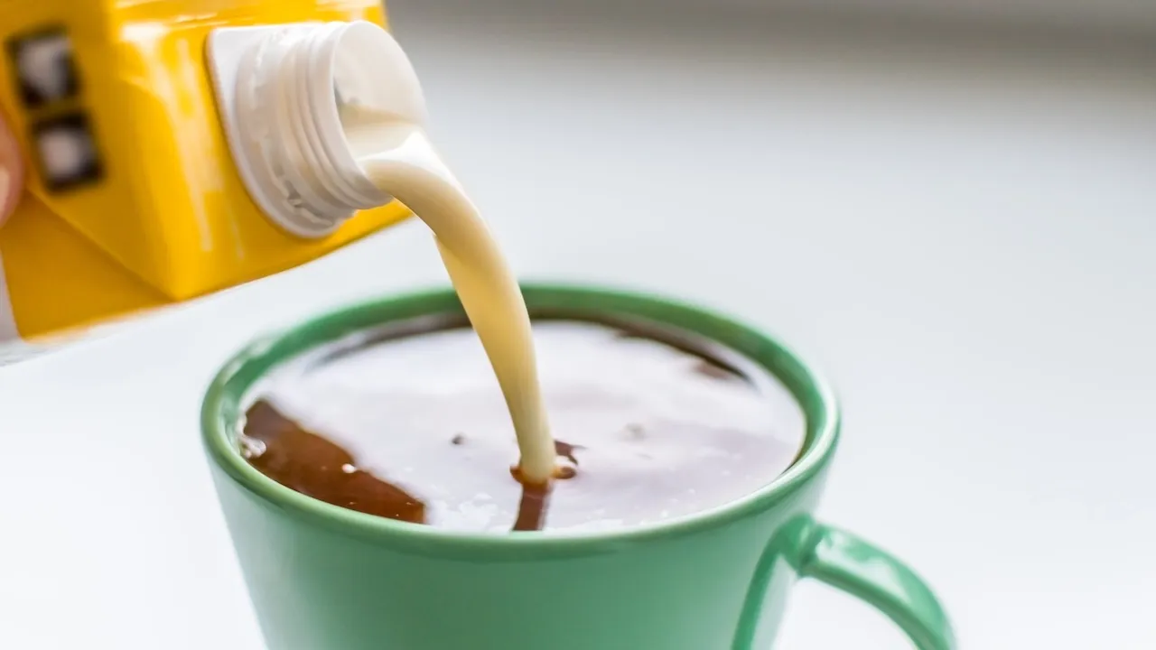 Pouring plant-based milk to a cup of coffee