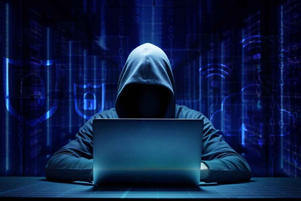 A hooded hacker using a computer, representing the hacker arrest.