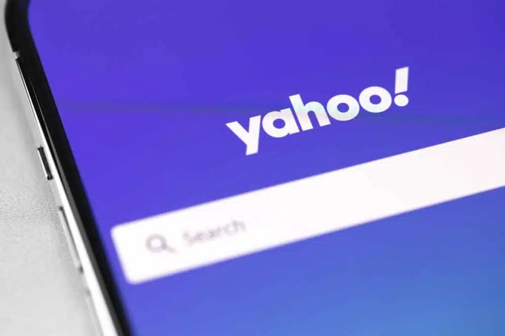 Close up of Yahoo logo and search bar displayed on a smartphone, representing the Yahoo settlement.