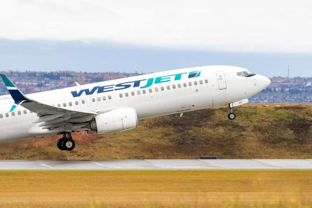 A WestJet plane taking off a runway, representing the WestJet baggage fee settlement.