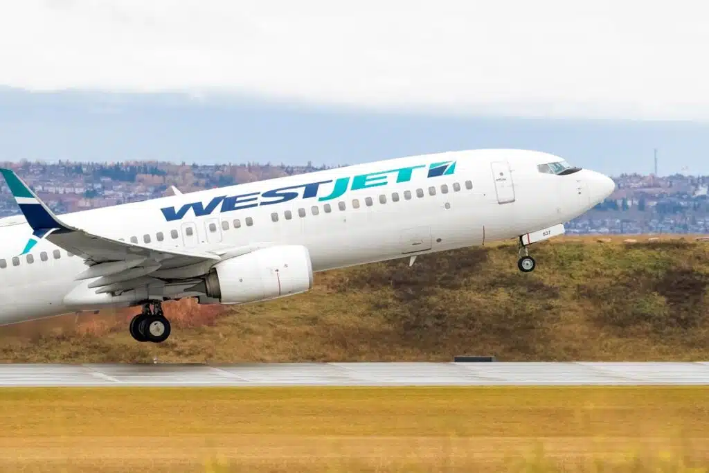 A WestJet plane taking off a runway, representing the WestJet baggage fee settlement.