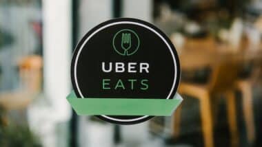An Uber Eats sign on the door of local restaurant.