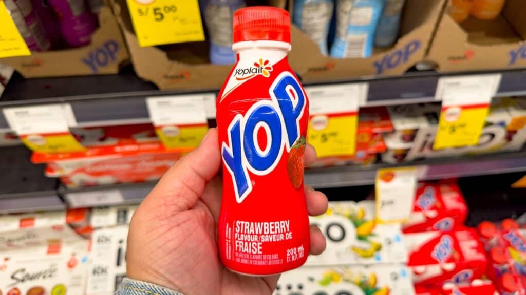 A view of a hand holding bottle of Yop yogurt drink, on display at the store.