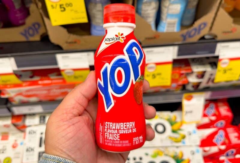 A view of a hand holding bottle of Yop yogurt drink, on display at the store.