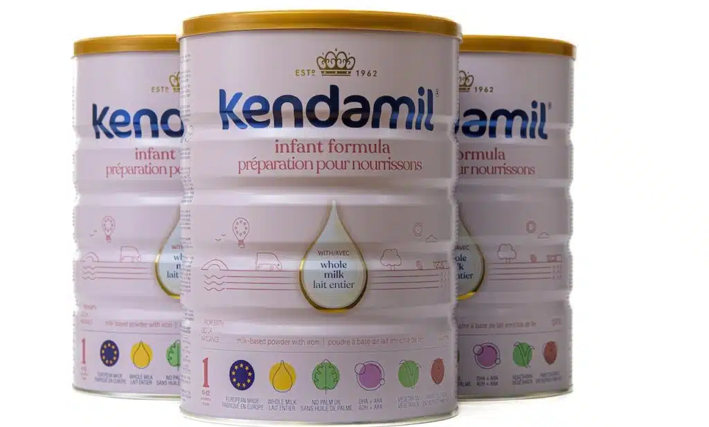 Three cans of Kendamill baby formula.