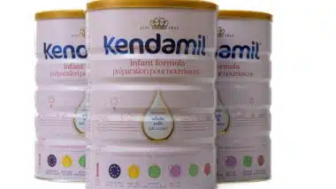 Three cans of Kendamill baby formula.