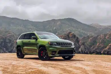 Green Jeep Grand Cherokee SRT showing the passenger side of the car with mountains in the background