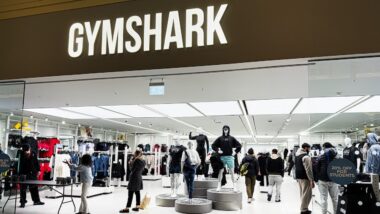 Inside the Gymshark shop, shoppers browse athleticwear around mannequins and bright lighting.