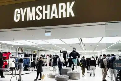 Inside the Gymshark shop, shoppers browse athleticwear around mannequins and bright lighting.